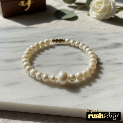 Artisan hand-knotted natural freshwater pearl bracelet featuring a prominent central Baroque pearl and gold-toned barrel clasp.