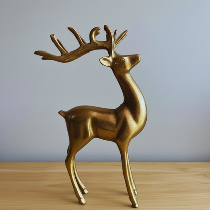 Gold deer figurine on a wooden surface with a gray background