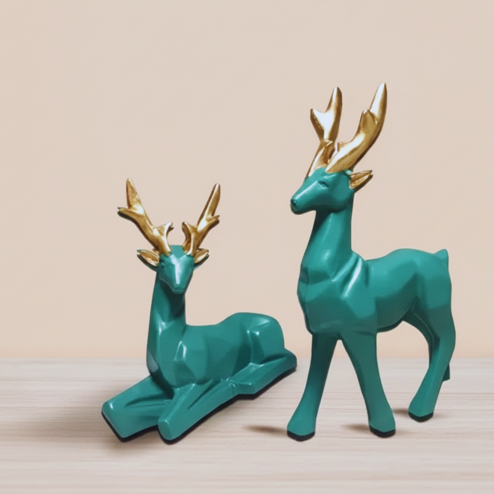 Two teal deer figurines with gold antlers on a beige background