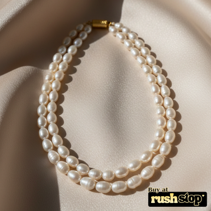 Luminous multi-strand freshwater pearl necklace with hand-selected high-luster pearls and gold-toned statement clasp.