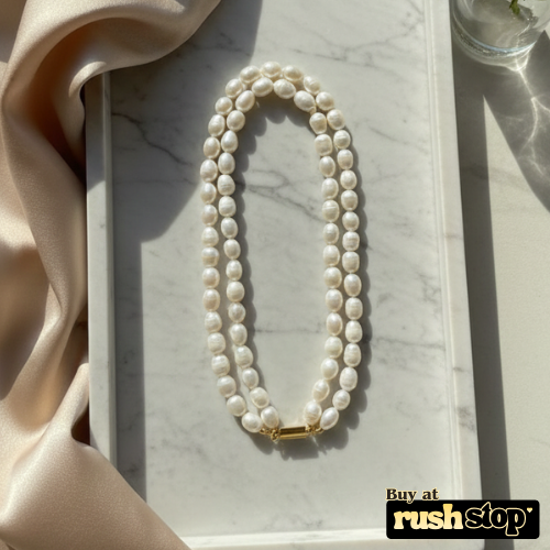 Luminous multi-strand freshwater pearl necklace with hand-selected high-luster pearls and gold-toned statement clasp.