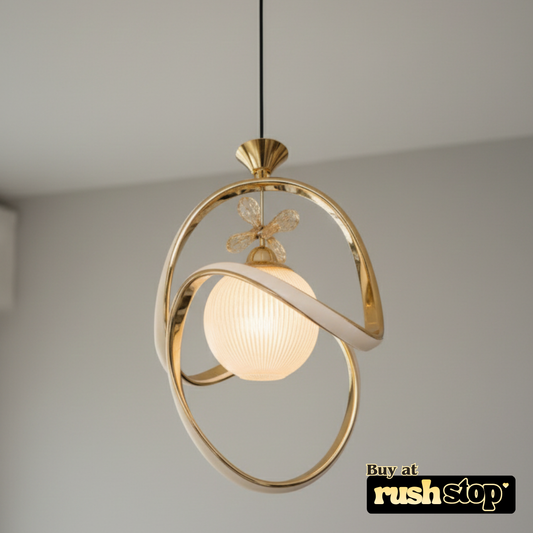 Gold pendant light fixture with a soft glow on a neutral background, featuring the brand 'rushstop'.