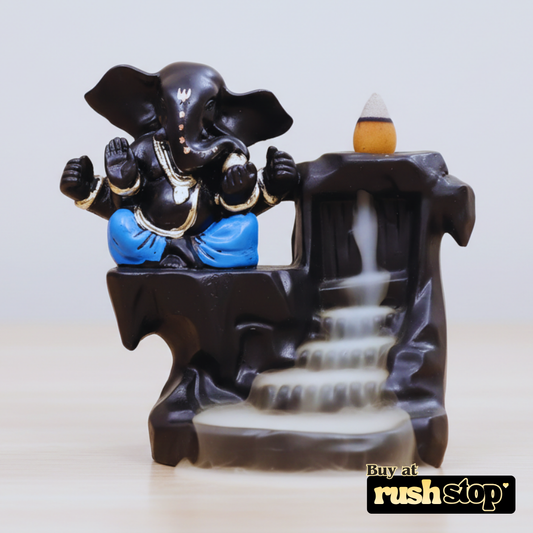 Decorative figurine of an elephant with a waterfall and candle on a light background