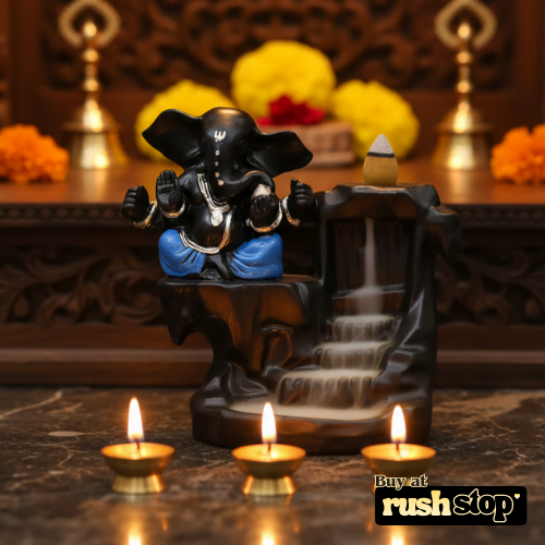 Decorative Ganesha statue with water fountain and candles on a marble surface.