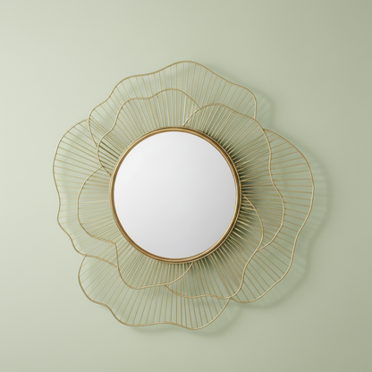 Decorative wall mirror with gold wireframe design on a light green wall