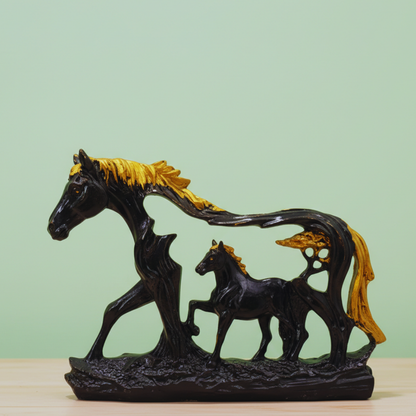 Decorative sculpture of a horse and foal with gold mane on a light green background