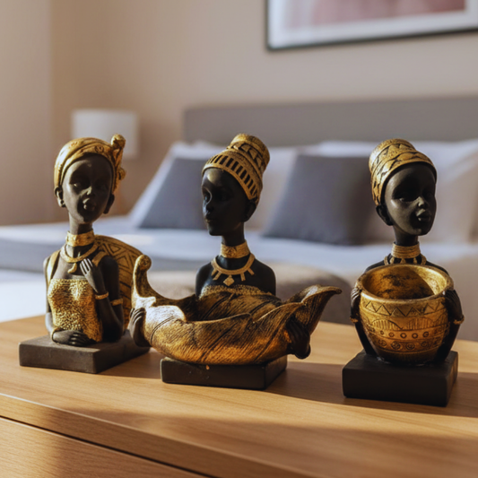 Three decorative figurines of women on a wooden surface with a blurred background