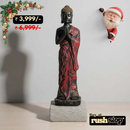 Buddha statue with red and black robes on a gray background, with Christmas decorations and Santa Claus figure.