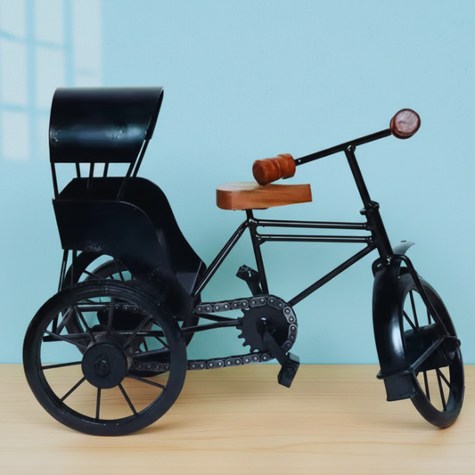 Model of a three-wheeled vehicle with a black frame and wooden seat on a light blue background.
